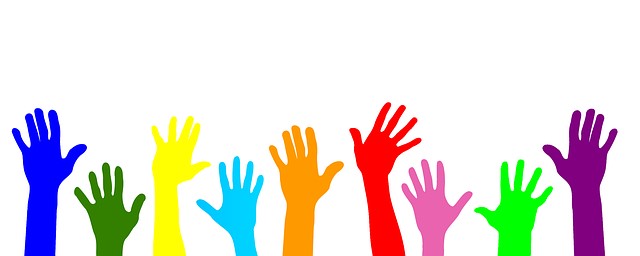 Multi coloured hands raised in unison offering support